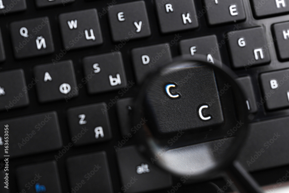 Magnifying Glass on black keyboard Magnifying Glass on black keyboard