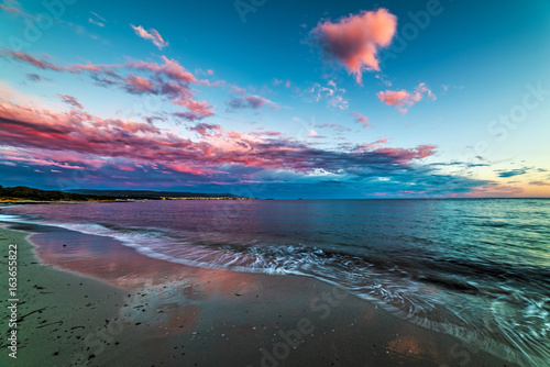 Pink clouds over the sea in Alghero at sunset