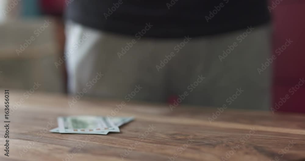 slow motion front shot of man counting dollars on wood table slow motion front shot of man counting dollars on wood table