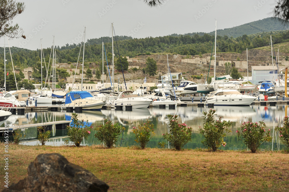 Yachts anchored at the marina.Sailboat harbor, many moored sail yachts in the sea port, modern water transport,summertime vacation, luxury lifestyle and wealth concept.Modern yachts in harbor