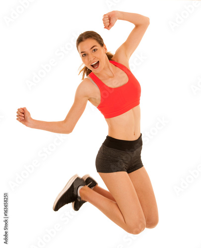 Attractive sporty woman jumps islated over white background