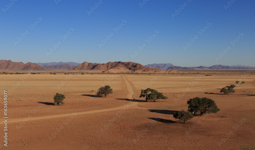 Road at african savanna landscape. View from Elim Dune, Sossusvlei. Namibia, South of Africa. Road at african savanna landscape. View from Elim Dune, Sossusvlei. Namibia, South of Africa.
