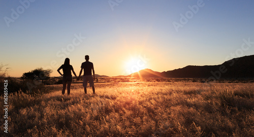Couple at african savanna landscape. Namibia, South of Africa.