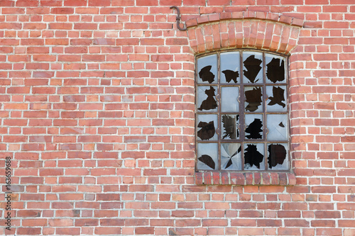 Old brick wall with broken window.
