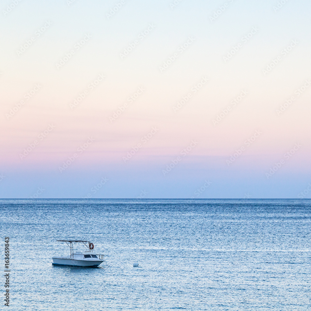 view of boat in sea in blue and pink twilight