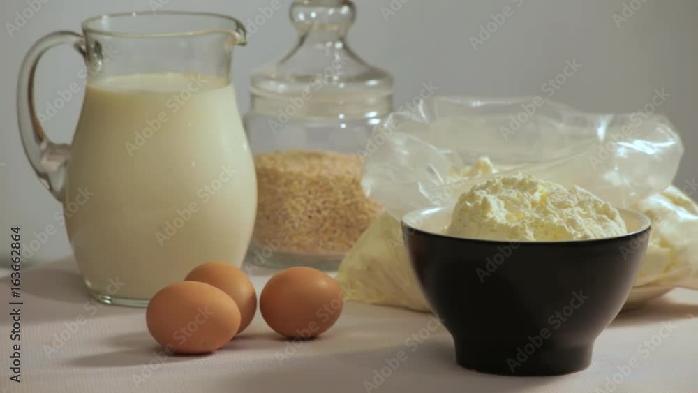 Milk and eggs on table. Ingredients for baking turning on table. Baking ingredients. Milk in glass bowl, flour and eggs. Cooking ingredients. Organic ingredients for cooking Milk and eggs on table. Ingredients for baking turning on table. Baking ingredients. Milk in glass bowl, flour and eggs. Cooking ingredients. Organic ingredients for cooking