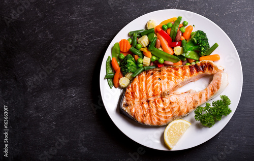 plate of grilled salmon steak with vegetables