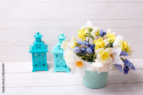Fototapeta Naklejka Na Ścianę i Meble -  Muscaries and yellow narcissus flowers in vase  and two lanterns  on  wooden background