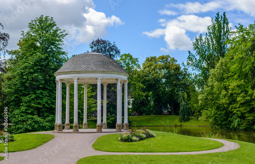 Domed gazebo in a lush ark reflected in a lake
