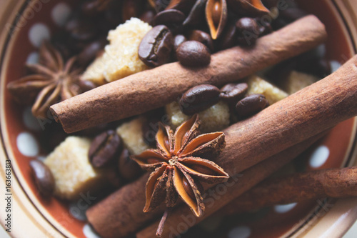 Ingredients for making coffee. Coffee beans, anise, cinnamon sticks, brown sugar in dark ethnic dishes.