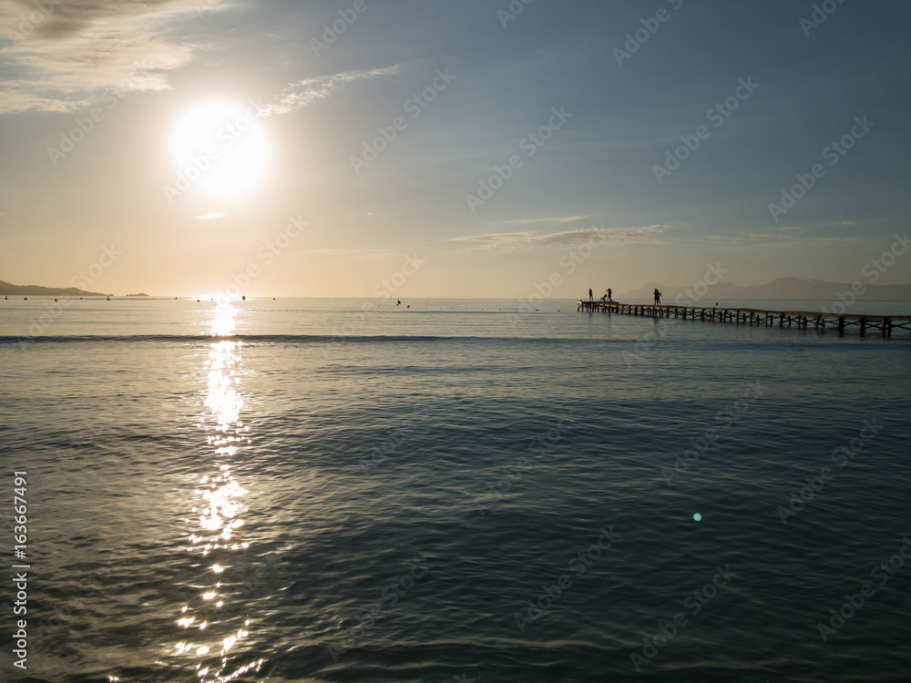 Wooden pier, beautiful sunrise, Majorca island Muro beach