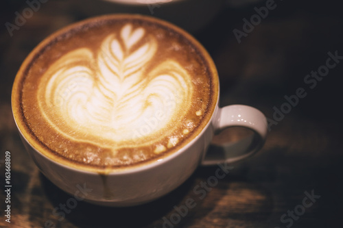 latte art, perfect and beautiful milk bubble coffee pattern in dark tone.