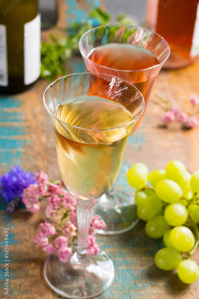 Cold summer wines, white and rose, served in beautiful glasses on terrace in cafe with romantic flowers