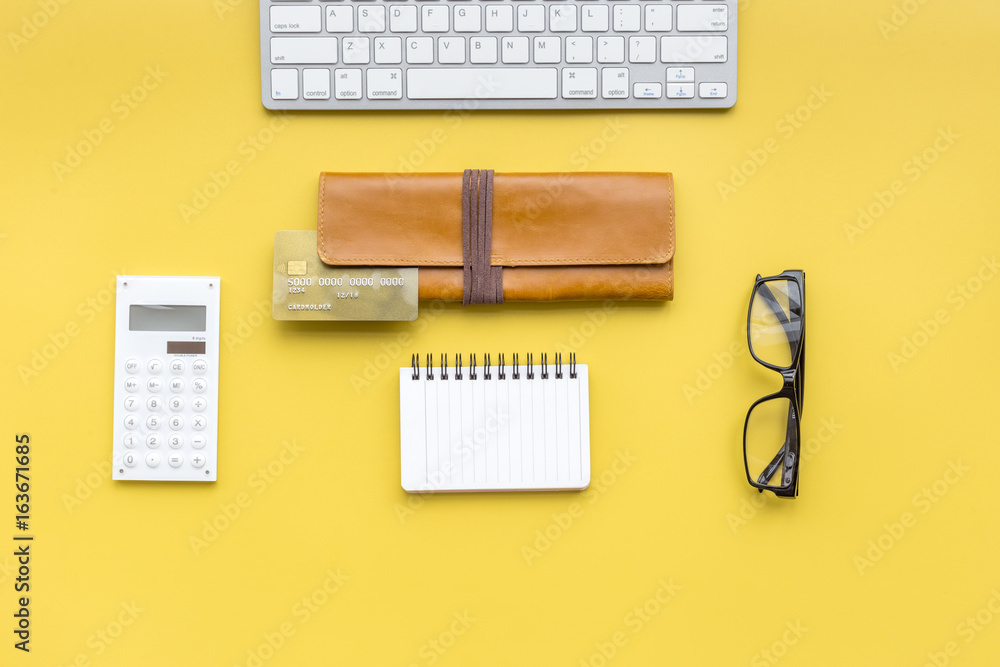 Concept of paying by credit card online. Bank card in purse nearby keyboard on yellow background top view copyspace Concept of paying by credit card online. Bank card in purse nearby keyboard on yellow background top view copyspace