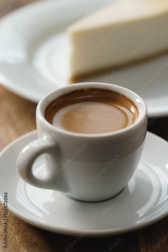 fresh espresso and cheesecake on table