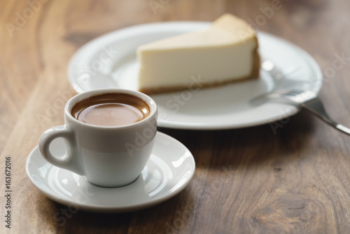 fresh espresso and cheesecake on table