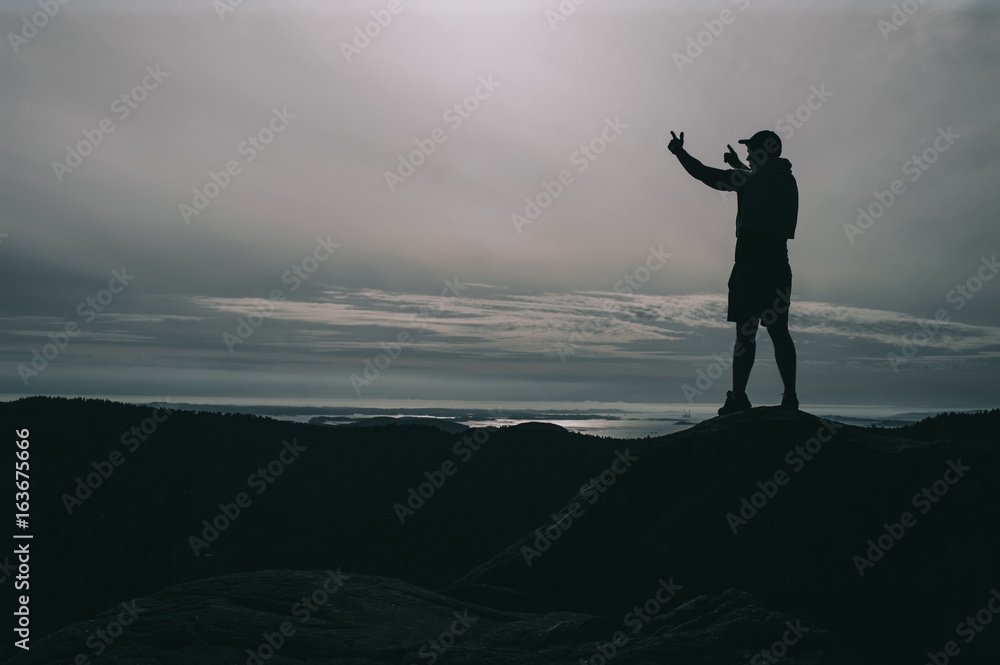 Fototapeta premium A lonely guy stands on a stone in norway