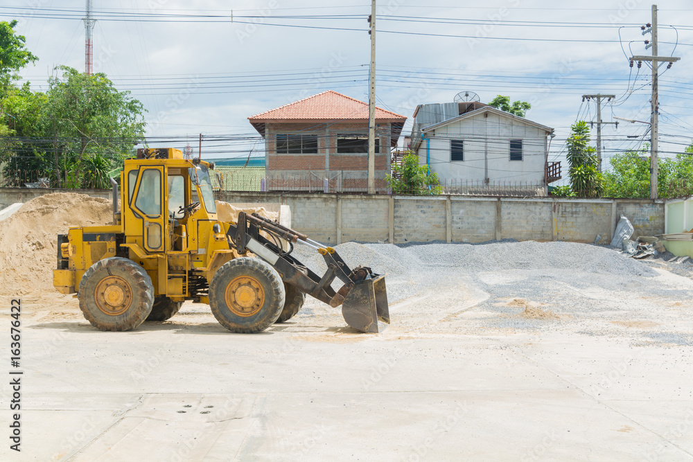 Yellow Hydraulic Tractor Loader or Backhoe earthmover woking in Construction site