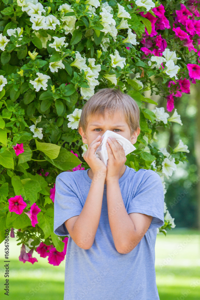 Allergy. Little boy is blowing his nose near tree in bloom. Allergy. Little boy is blowing his nose near tree in bloom.