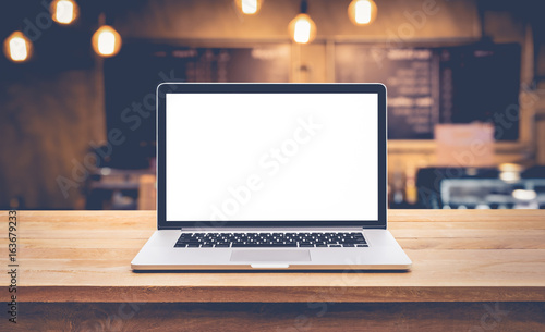 Modern computer,laptop with blank screen on table with blur cafe,restaurant background