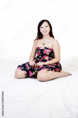 Plump Chinese American Woman Sitting In Floral Dress