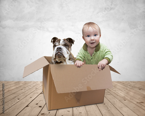 baby and dog in a box