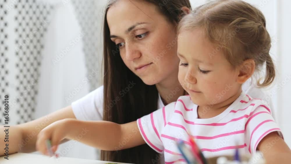 Mother and daughter doing a puzzle together in the light living room Mother and daughter doing a puzzle together in the light living room