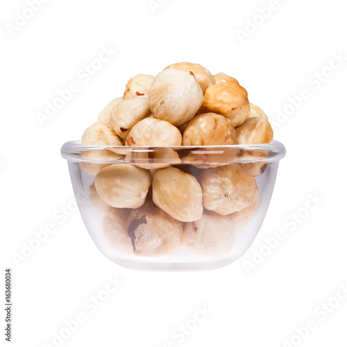 White background with saucepan full of hazelnuts.