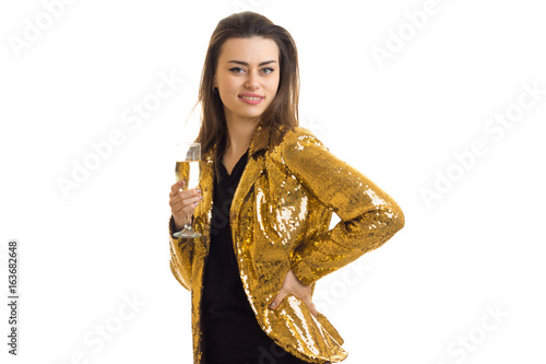 cheerful brunette woman in golden jacket with glass of champgane photo