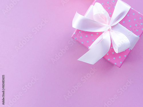 gift box with colorful satin ribbon  pink background  greetings on women s day  Mother s Day  Valentine s Day  Birthday  Christmas  space for text