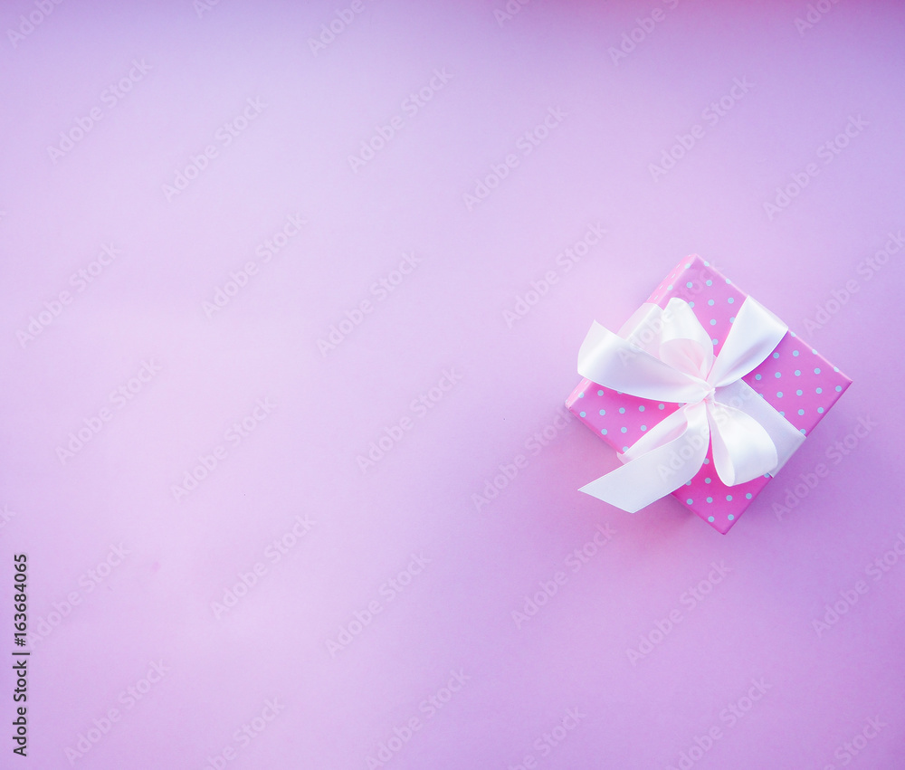 gift box with pink ribbon on pink background gift box with pink ribbon on pink background