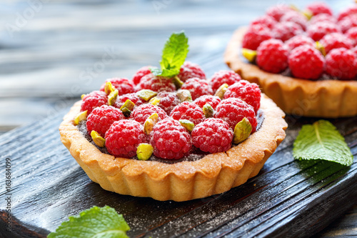 Obraz na płótnie Mini tarts with chocolate, raspberry and pistachio.