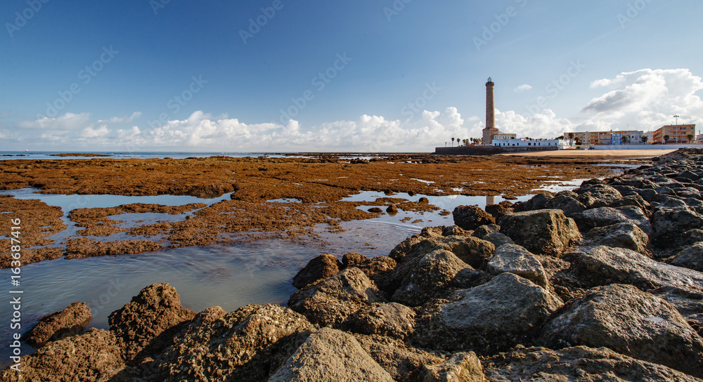 Obraz premium The lighthouse and the Chipiona embankment