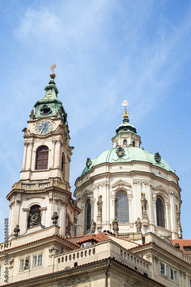 View of tower and dome of Church of Saint Nicholas (St. Nicholas Church) in Mala Strana or Lesser Town in Prague, Czech Republic, in the daytime.