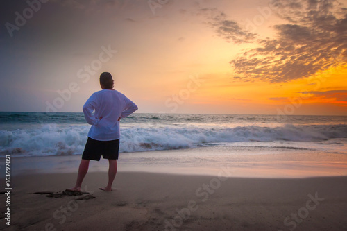A man looks at the ocean. M...
