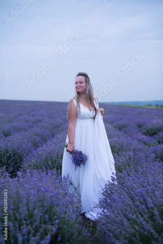 Young girl in white dress in lavender field