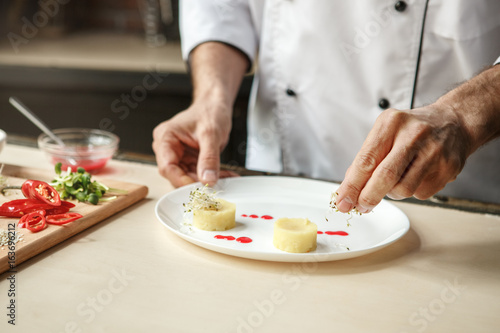 Mature man professional chef cooking meal indoors