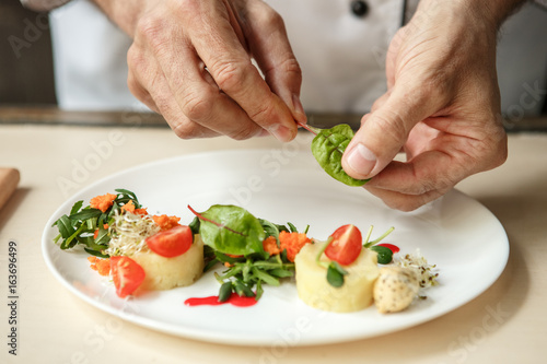 Фотография Mature man professional chef cooking meal indoors