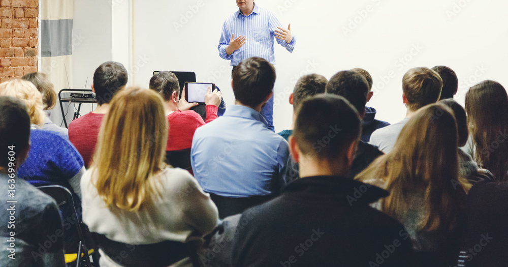 Adult students listen to professor's lecture in small class room. Panoramic aspect ratio. - obrazy, fototapety, plakaty 