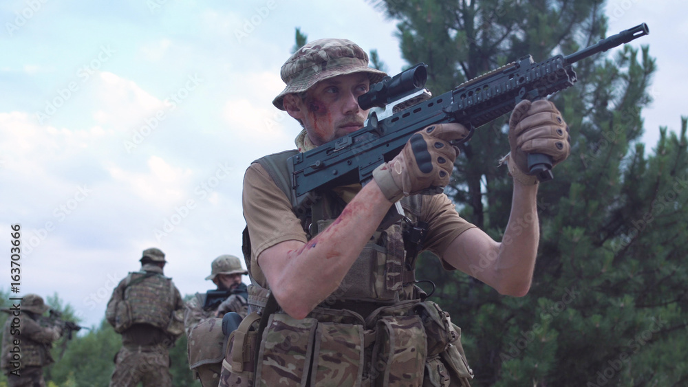 Fototapeta premium Group of soldiers in a camouflage and with weapon carry out investigation of the territory