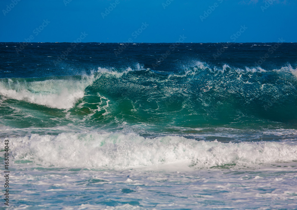 Fototapeta premium Breaking waves of the Indian Ocean at the Wild Coast of South Africa with cloudy sky
