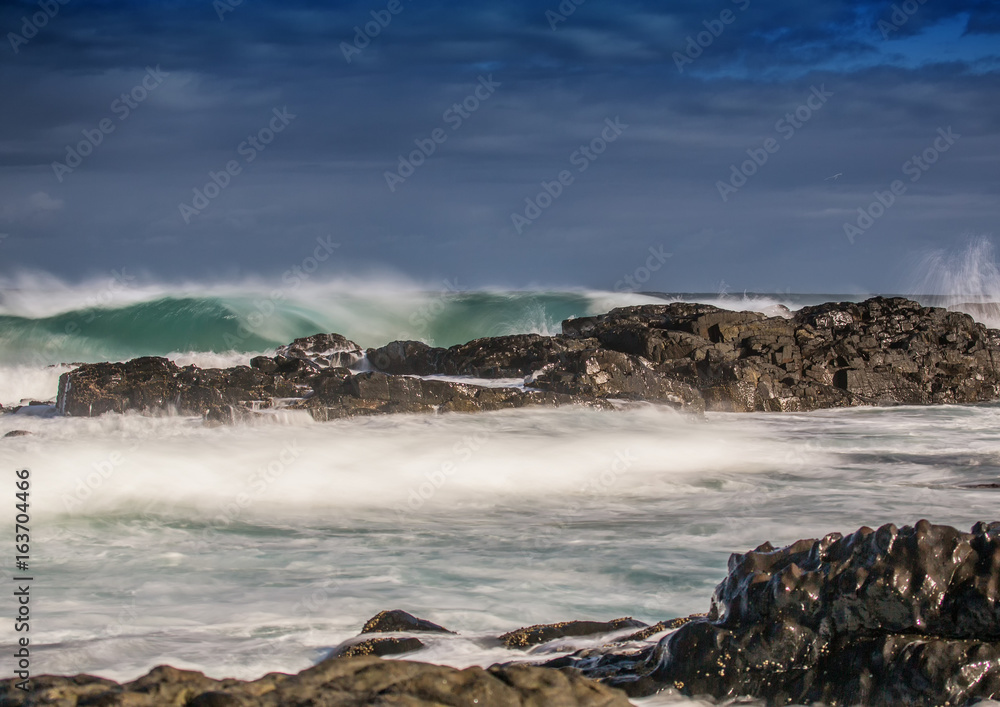 Fototapeta premium Long time exposure of waves around rocks at the Wild Coast at the Indian Ocean in South Africa