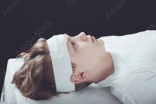 Boy Lying Down with Bandage Wrapped Around Head photo