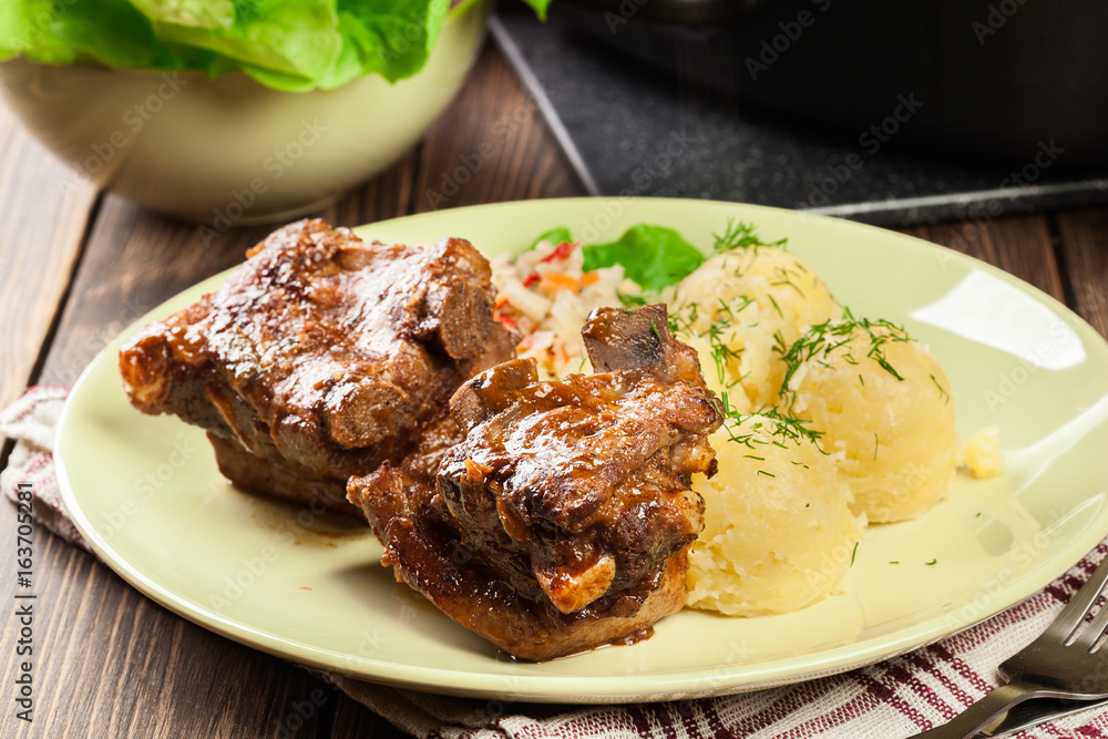 Pork spare ribs served with mashed potatoes and sauce Pork spare ribs served with mashed potatoes and sauce