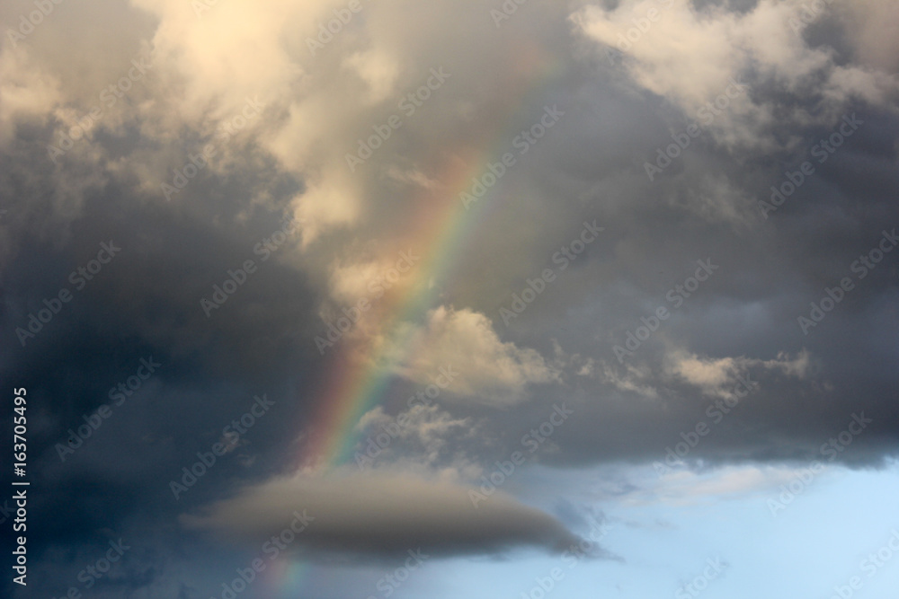 Evening sky after rain, rainbow leaves in a cloud shaped like a whale. Fabulously beautiful sky. Rainbow in the sky..