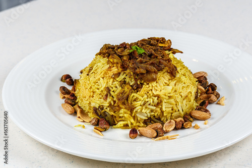 Traditional Middle Eastern fish and fried rice dish with fried pine nuts