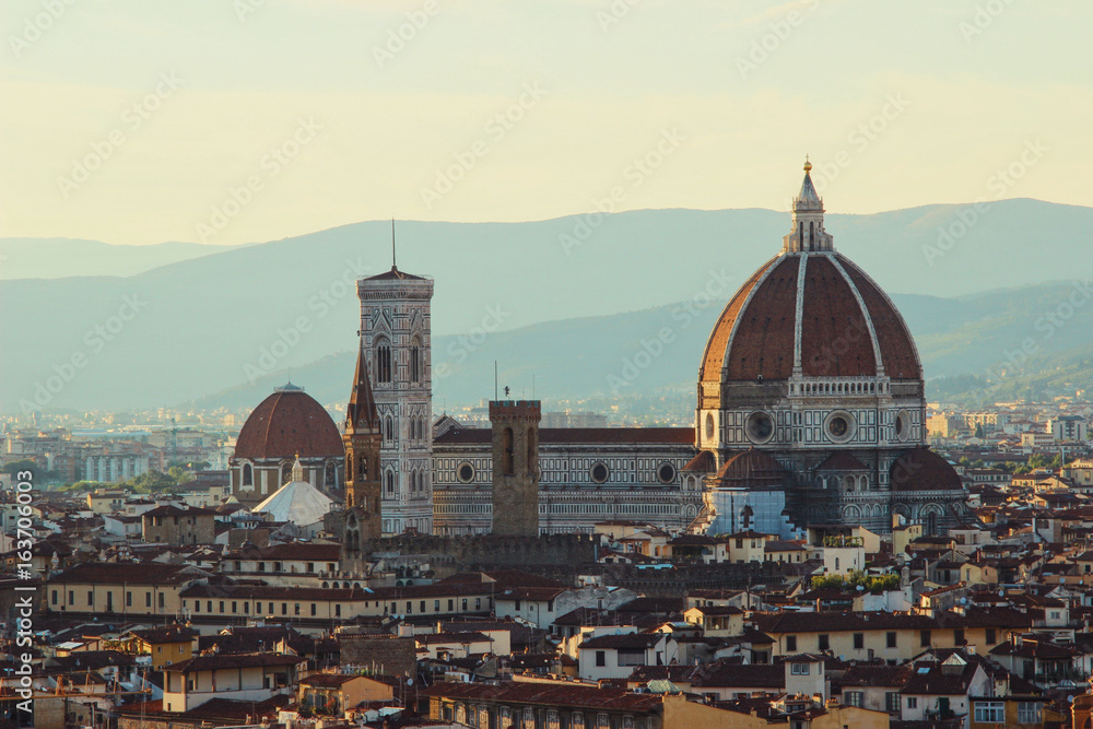 Elevated view of Santa Maria Del Fiore cathedral with mountains in the background at sunset