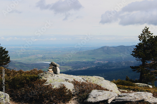 Pile of rocks in a peak of Madrid Sierra, with a background view of Segovia photo