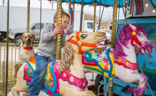 Cash Cotton enjoying a ride on a semi-creepy carousel