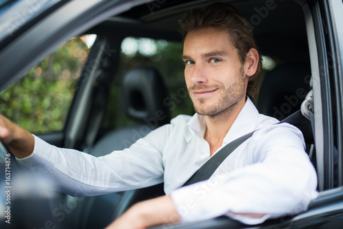 Smiling man driving his car © Minerva Studio